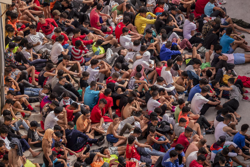 Unaccompanied minors who crossed into Spain are gathered outside a warehouse used as temporary shelter as they wait to be tested for COVID-19 at the Spanish enclave of Ceuta, near the border of Morocco and Spain, Wednesday, May 19, 2021. Social services for the small city perched on an outcropping in the Mediterranean buckled under the strain after more than 8,000 people crossed into Spanish territory during the previous two days. (AP Photo/Bernat Armangue)