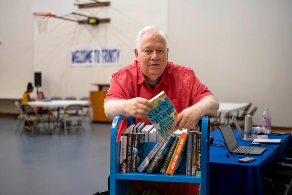 Pastor Roger Bruns is pictured with a rack of books in the temporary space for the Almonte Library inside Trinity Lutheran Church in Oklahoma City.