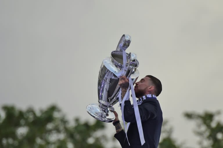 Real Madrid's Sergio Ramos kisses the UEFA Champions League trophy during celebrations of the team's win on Plaza Cibeles in Madrid with thousands of fans