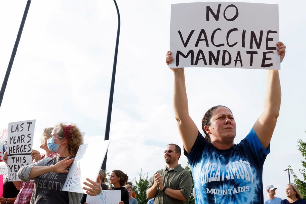 Jamie Horning, 43, of Union Town, raises a sign to protest against the coronavirus vaccine mandates at Summa Health Hospital in Akron, Ohio, US, 16 August, 2021. (REUTERS)