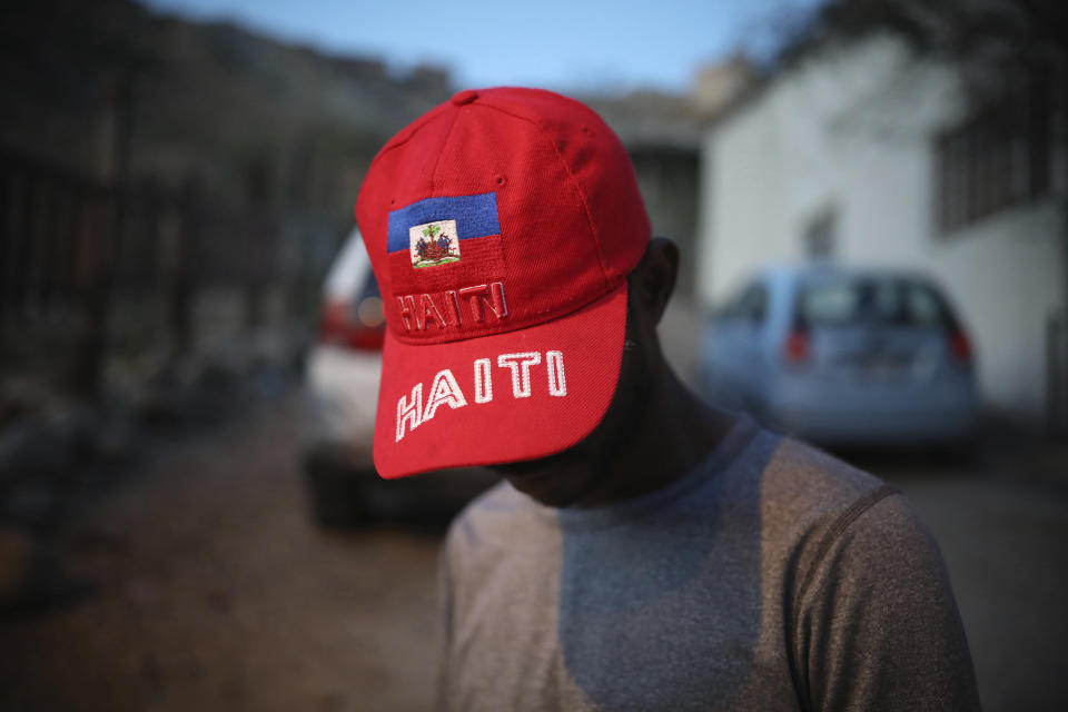 ARCHIVO - Esta fotografía de archivo del 4 de mayo de 2018 muestra al migrante haitiano Pierre Franzzi, quien enseña su gorra roja con la bandera de su país afuera de la iglesia Embajadores de Jesús en Tijuana, México. (AP Foto/Emilio Espejel, archivo)