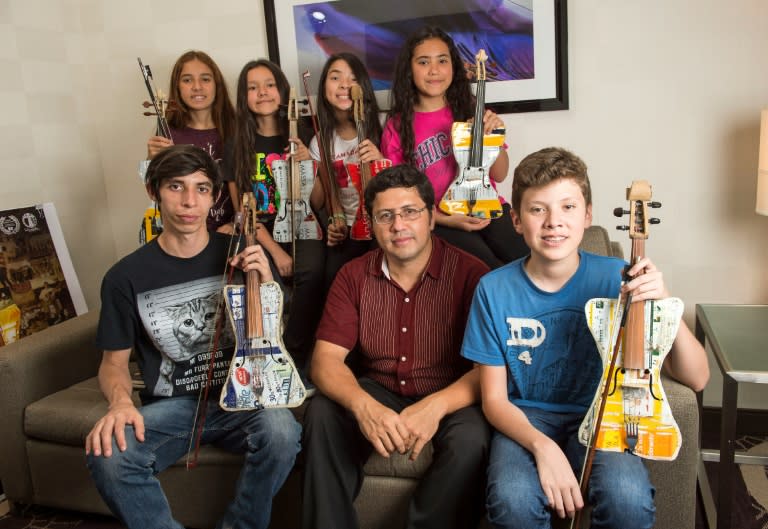 Young musicians from the Recycled Orchestra of Cateura, Paraguay, and their music director Favio Chavez (C), pose for a photo in Los Angeles, on September 21, 2016