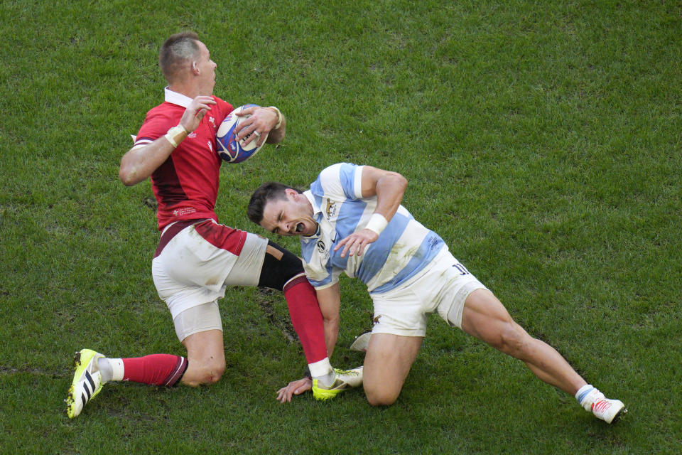 Wales' Dan Biggar, left, is challenged by Argentina's Mateo Carreras during the Rugby World Cup quarterfinal match between Wales and Argentina at the Stade de Marseille in Marseille, France, Saturday, Oct. 14, 2023. (AP Photo/Daniel Cole)