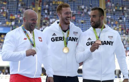 2016 Rio Olympics - Athletics - Victory Ceremony - Men's Discus Throw Victory Ceremony - Olympic Stadium - Rio de Janeiro, Brazil - 13/08/2016. Gold medallist Christoph Harting (GER) of Germany, silver medallist Piotr Malachowski (POL) of Poland and bronze medallist Daniel Jasinski (GER) of Germany pose with their medals. REUTERS/Alessandro Bianchi