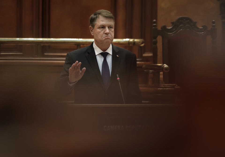 Romania's President Klaus Iohannis gestures during his speech at the parliament in Bucharest, Romania, Tuesday, Feb. 7, 2017. Romania's president told lawmakers Tuesday the country is in a "fully-fledged" political crisis, after hundreds of thousands demonstrated against a government measure that would weaken the country's anti-corruption drive. (AP Photo/Vadim Ghirda)