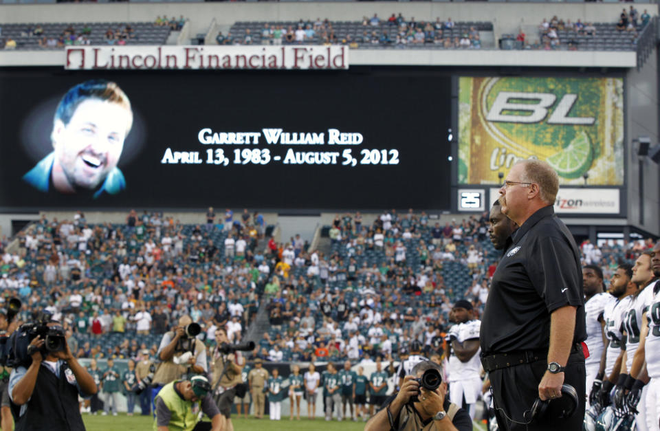 Philadelphia Eagles coach Andy Reid, right, stands on the field as sign shows a photo of his son Garrett Reid, who died Sunday, before an NFL preseason football game against the Pittsburgh Steelers on Thursday, Aug. 9, 2012, in Philadelphia. (AP Photo/Mel Evans)