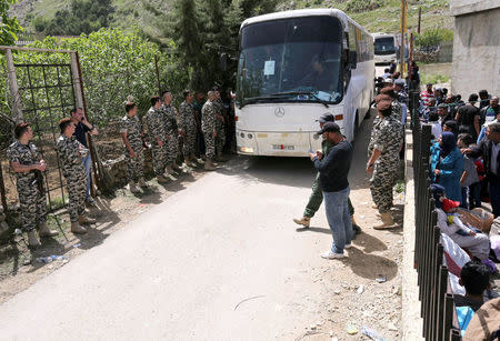 Lebanese general security members stand near buses that will take Syrian refugees, who fled to Lebanon, back to Syria from the southern village of Shebaa, Lebanon April 18, 2018. REUTERS/Aziz Taher