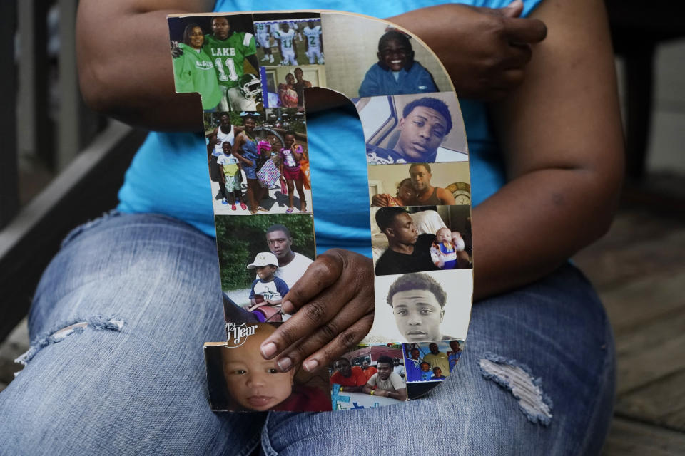 Tammie Townsend holds a collage of photographs of her eldest son, Willie Jones Jr., 21, with family members, as she speaks about the incident where he was found hanging from a tree in his girlfriend's Scott County yard three years ago, April 27, 2021 at his grandmother's home in Forest, Miss. The collage are in the form of a "D," which played off his nickname, "Duke." A Hinds County judge recently awarded the family $11 million in a civil suit related to his death. (AP Photo/Rogelio V. Solis)