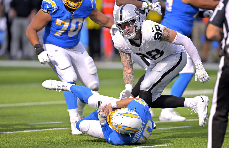 Oct 1, 2023; Inglewood, California, USA; Los Angeles Chargers quarterback <a class="link " href="https://sports.yahoo.com/nfl/players/32676" data-i13n="sec:content-canvas;subsec:anchor_text;elm:context_link" data-ylk="slk:Justin Herbert;sec:content-canvas;subsec:anchor_text;elm:context_link;itc:0">Justin Herbert</a> (10) is sacked by <a class="link " href="https://sports.yahoo.com/nfl/teams/las-vegas/" data-i13n="sec:content-canvas;subsec:anchor_text;elm:context_link" data-ylk="slk:Las Vegas Raiders;sec:content-canvas;subsec:anchor_text;elm:context_link;itc:0">Las Vegas Raiders</a> defensive end <a class="link " href="https://sports.yahoo.com/nfl/players/31938" data-i13n="sec:content-canvas;subsec:anchor_text;elm:context_link" data-ylk="slk:Maxx Crosby;sec:content-canvas;subsec:anchor_text;elm:context_link;itc:0">Maxx Crosby</a> (98) in the fourth quarter at SoFi Stadium. Mandatory Credit: Jayne Kamin-Oncea-USA TODAY Sports