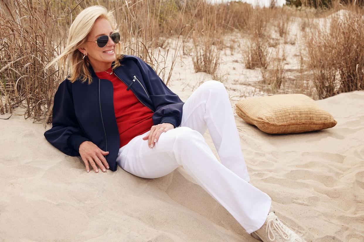 first lady jill biden lying on a sandy beach, smiling into the distance