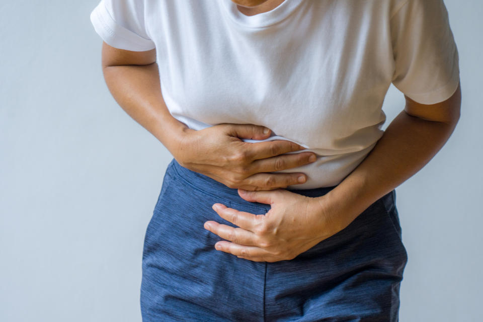 Woman having painful stomachache. Persistence of various GI symptoms can be a key indicator that you should seek medical attention, regardless of cancer risk. (Getty Images)