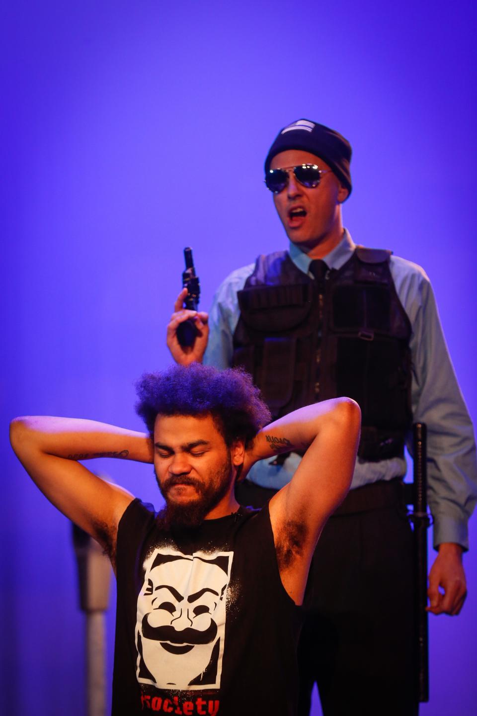 Jonathan Newman as Ossifer prepares to point a prop gun at Mikil Hernandez as Moses during Springfield Contemporary Theatre's dress rehearsal of "Pass Over" at the Historic Fox Theatre on Wednesday, July 19, 2023. "Pass Over" runs July 21-23, 27-30 and Aug. 3-6, 2023.