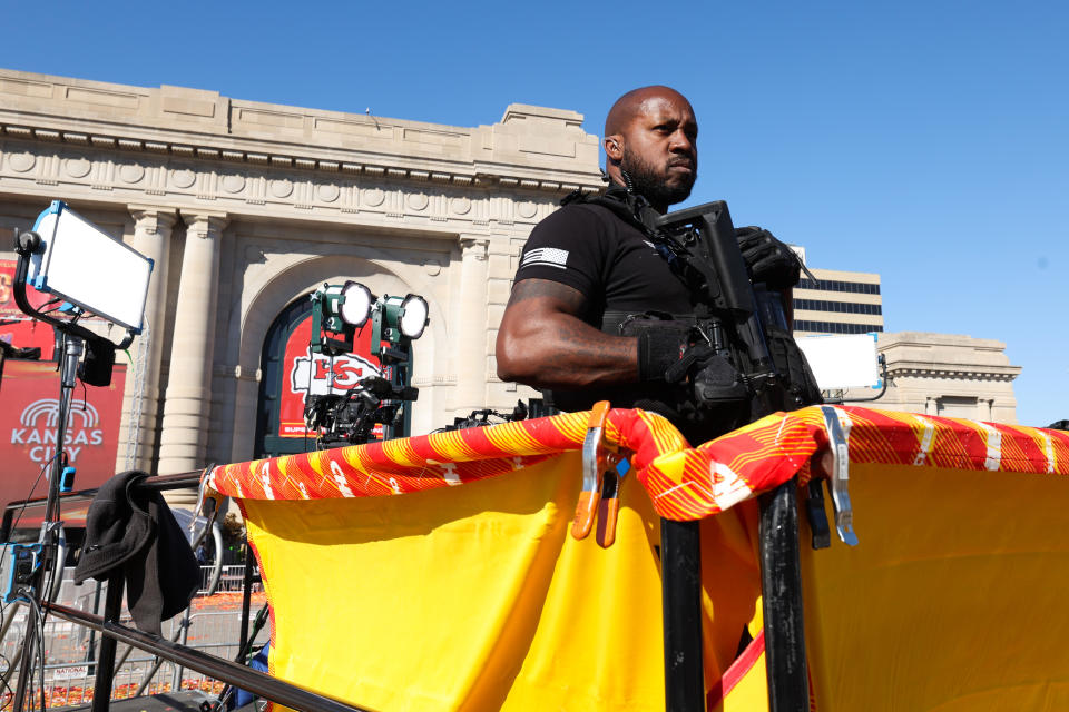 A law enforcement officer stands behind a red and yellow banner after the shooting at the Kansas City parade.