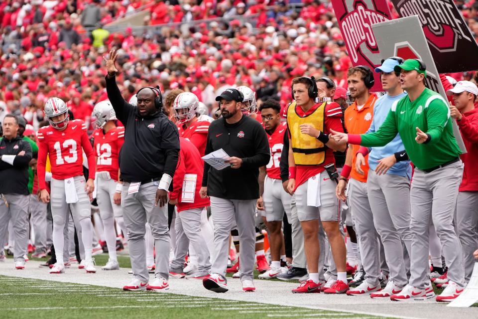Ohio State running backs coach Tony Alford, head coach Ryan Day and offensive line coach Justin Frye signal in a call from the sideline during Saturday's 20-12 win over Penn State.
