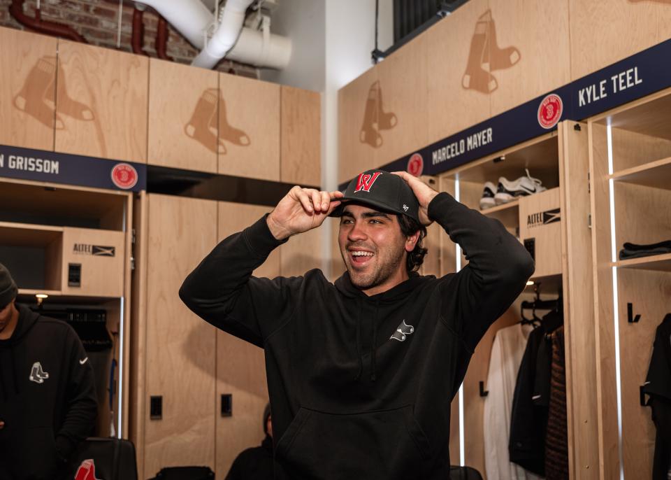Boston Red Sox prospect Marcelo Mayer is all smiles when trying on a WooSox hat during the Red Sox Development Program inside the Sox clubhouse at Fenway Park on Wednesday.
