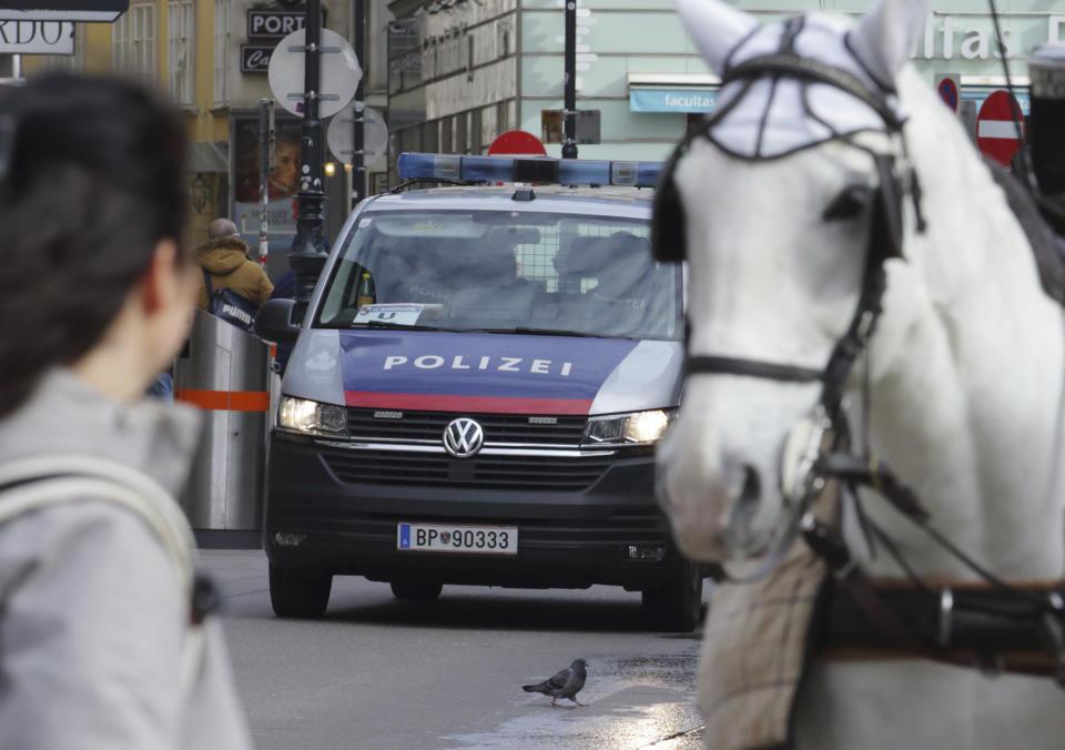 A police van drives past Fiaker horses at St. Stephen's cathedral in Vienna, Austria, Wednesday, Mar 15, 2023. Austrian police are warning of a possible “Islamist-motivated attack” targeting churches in Vienna. They cited undisclosed information the country’s intelligence service had received. (AP Photo/Heinz-Peter Bader)