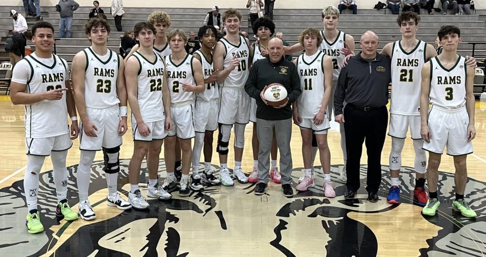 Flat Rock's basketball team gathers around coach Rick Smith after he earned his 100th career game with the Rams Tuesday night. Flat Rock beat SMCC 57-42.