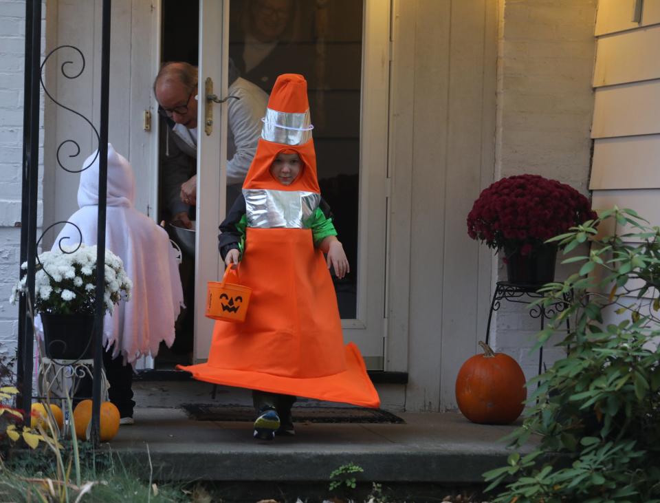 William Wells, 5, heads to his parents, while his brother, Samuel, 3, gets candy from a neighbor on Halloween night,  Oct. 31, 2022.  The brothers were trick or treating with their parents on Chestnut Hill Drive in Irondequoit.