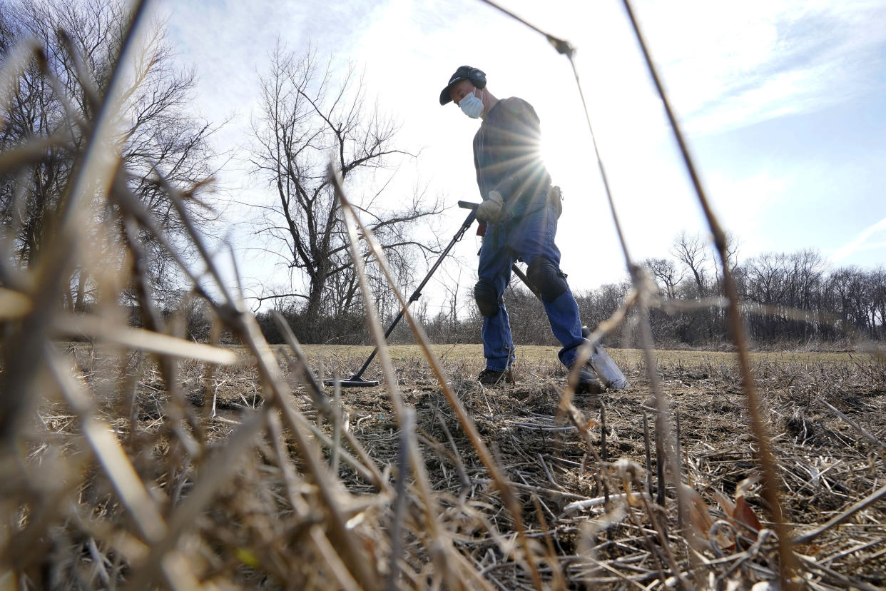 Amateur historian Jim Bailey uses a metal detector to scan for Colonial-era artifacts in a field, Thursday, March 11, 2021, in Warwick, R.I. In 2014, Bailey, who holds a degree in anthropology from the University of Rhode Island, found a 17th-century Arabian silver coin at a farm in Middletown, R.I., that he contends was plundered in 1695 by English pirate Henry Every from Muslim pilgrims sailing home to India after a pilgrimage to Mecca. (AP Photo/Steven Senne)