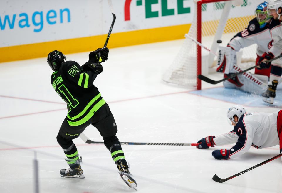 Dallas Stars forward Jason Robertson (21) shoots the puck past Columbus Blue Jackets goaltender Daniil Tarasov (40) for a goal during the first period of an NHL hockey game Thursday, Dec. 2, 2021, in Dallas. (AP Photo/Brandon Wade)