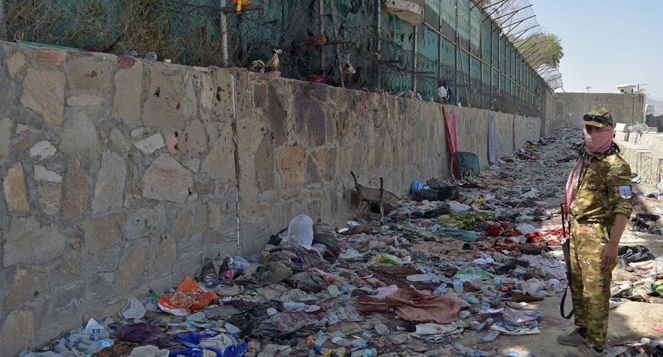 A Taliban fighter stands guard at the site of the twin suicide bombs at Kabul airport.