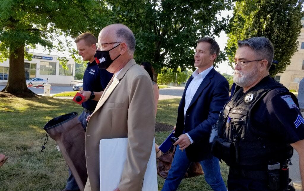 Former Gov. Eric Greitens, second from right, leaves the Boone County Courthouse on Wednesday with his attorney, Gary Stamper, masked, after a 7 1/2-hour deposition hearing in the child custody case stemming from his 2020 divorce.