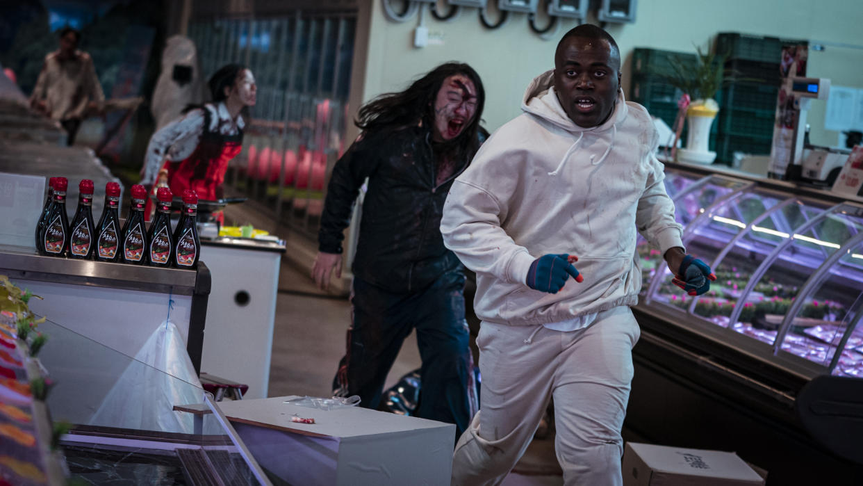  A contestant runs from some zombies in Netflix's Zombiverse reality TV show 