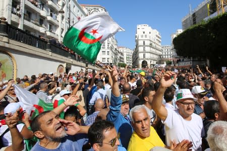 Demonstrators carry national flags and shout slogans during a protest against a proposed new hydrocarbons law in Algiers