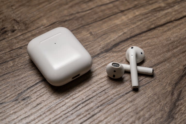 The Apple AirPods 2 with their charging case on a desk.