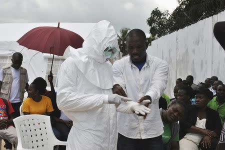 A volunteer health worker practises using a personal protective equipment (PPE) suit at a newly-constructed Ebola virus treatment centre in Monrovia, Liberia, September 21, 2014. REUTERS/James Giahyue