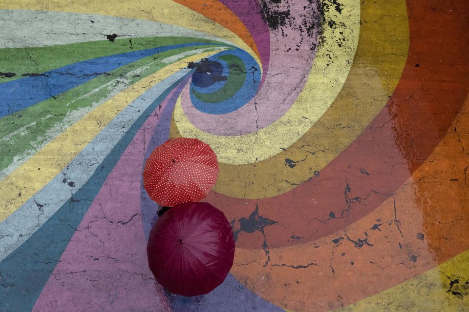 People with umbrellas walk along a pedestrian walkway on a rainy day in Santiago, Chile, June 13, 2024. (AP Photo/Matias Basualdo)