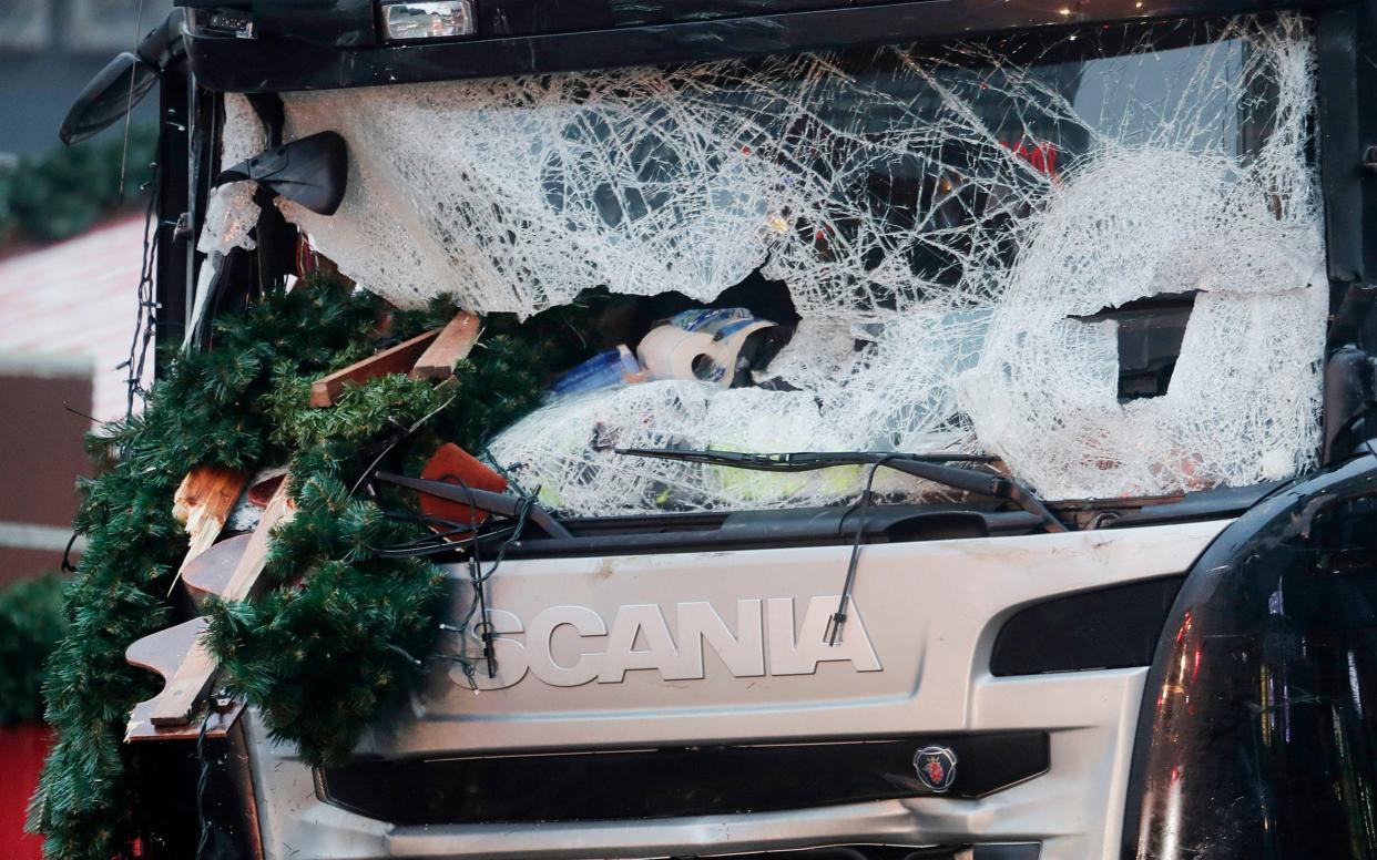 Debris is seen wedged in the smashed windscreen of a lorry, which was driven into a Christmas market in Berlin in 2016 - AP