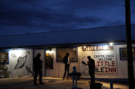 People stand around the Little A'Le'Inn during an event inspired by the "Storm Area 51" internet hoax, Thursday, Sept. 19, 2019, in Rachel, Nev. Hundreds have arrived in the desert after a Facebook post inviting people to "see them aliens" got widespread attention and gave rise to festivals this week. (AP Photo/John Locher)
