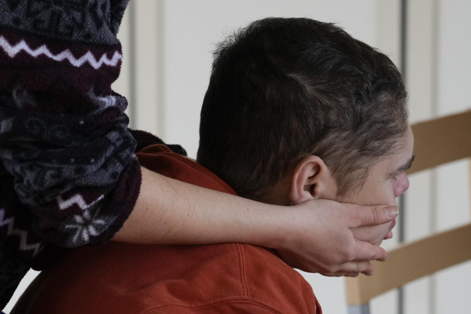 Edoardo Mira is caressed by a community assistant inside the Chicco community of L'Arche, an International charity that helps people with intellectual disabilities, in Ciampino, near Rome, Wednesday, March 22, 2023. The findings of expert reports commissioned by L’Arche itself reveal that their founder, Jean Vanier, perverted Catholic doctrine to justify his own sexual compulsions and abuse women and that the movement he created had at its core a secret, a mystical-sexual “sect” founded for the precise purpose of hiding the sect’s deviant activities from church authorities. (AP Photo/Gregorio Borgia)