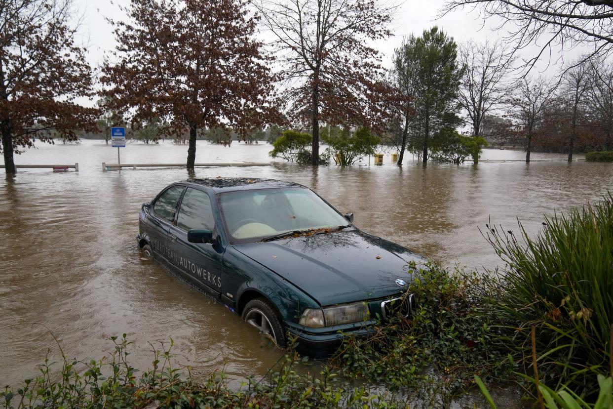 A car sits semi-submerged in flood waters at Camden on the outskirts of Sydney, Australia, Monday, July 4, 2022.