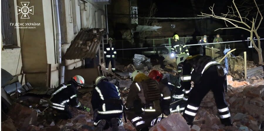 Rescue workers at the site of a missile impact in Kharkiv