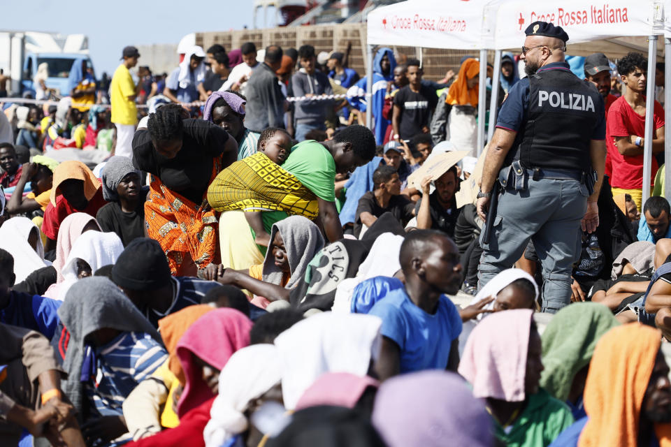 Migrants wait to be transferred from the Lampedusa Island to the mainland, Friday, Sept. 15, 2023. Thousands of migrants and refugees have landed on the Italian island of Lampedusa this week after crossing the Mediterranean Sea on small unseaworthy boats from Tunisia, overwhelming local authorities and aid organizations . (Cecilia Fabiano/LaPresse via AP)