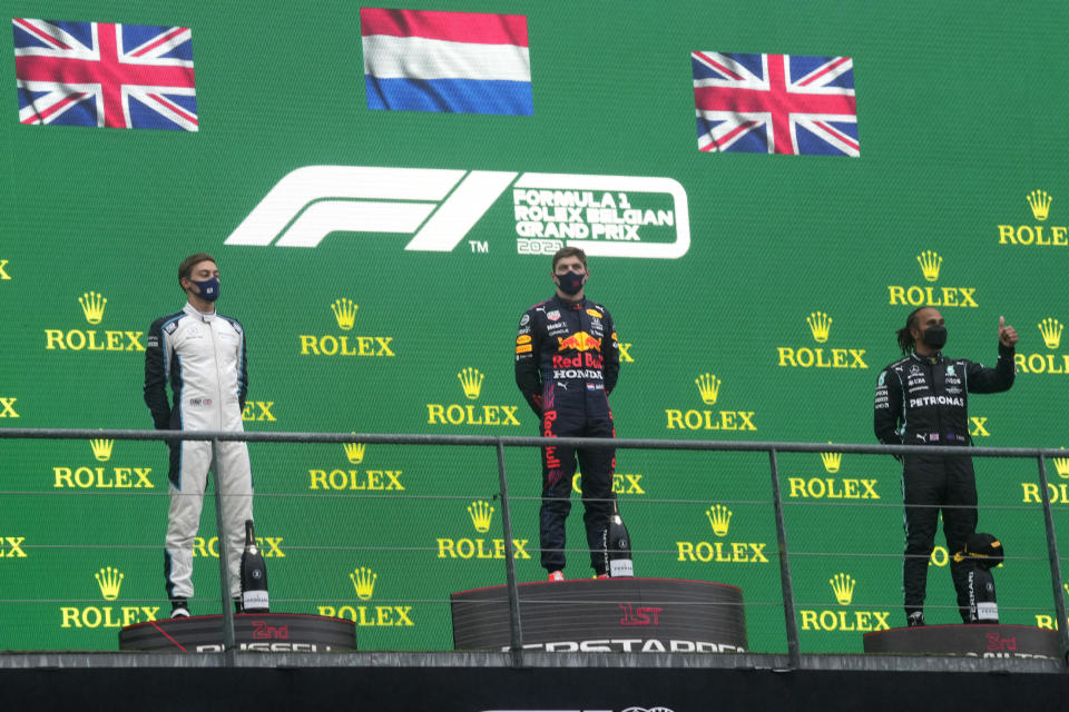 First place Red Bull driver Max Verstappen of the Netherlands, center, second place Williams driver George Russell of Britain, left, and third place Mercedes driver Lewis Hamilton of Britain, right, stand on the podium after the Formula One Grand Prix at the Spa-Francorchamps racetrack in Spa, Belgium, Sunday, Aug. 29, 2021. The race was red flagged due to weather conditions. (AP Photo/Francisco Seco)