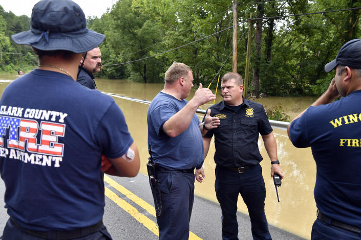 Members of the Lexington, Winchester, and Clark County Fire Departments and emergency medical services, coordinate efforts to get evacuees across the flooded Troublesome Creek in Jackson, Ky., Thursday, July 28, 2022. Flash flooding and mudslides were reported across the mountainous region of eastern Kentucky, where thunderstorms have dumped several inches of rain over the past few days. (AP Photo/Timothy D. Easley)