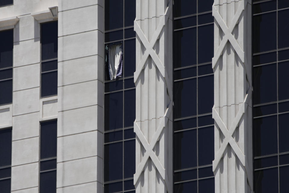 A curtain hangs out of a broken window on a hotel tower at Caesars Palace Hotel & Casino, Tuesday, July 11, 2023, in Las Vegas. (AP Photo/John Locher)