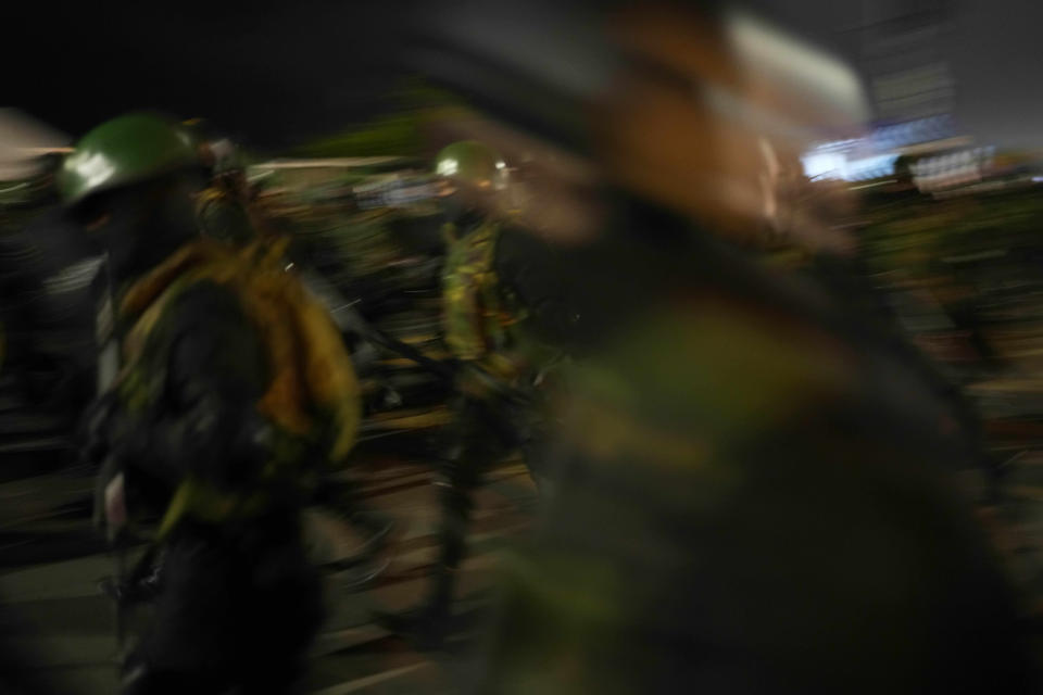 Army soldiers rush to remove the protesters from the site of a protest camp outside the Presidential Secretariat in Colombo, Sri Lanka, Friday, July 22, 2022. (AP Photo/Rafiq Maqbool)