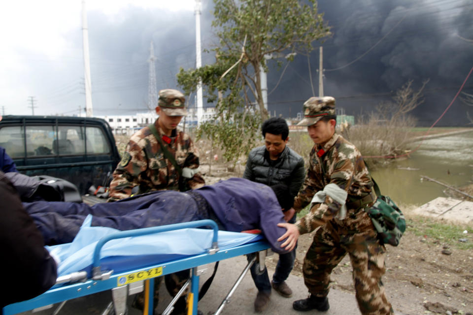 In this Thursday, March 21, 2019, photo, rescuers transport an injured person near the site of a factory explosion in a chemical industrial park in Xiangshui County of Yancheng in eastern China's Jiangsu province. The local government reports the death toll in an explosion at a chemical plant in eastern China has risen with dozens killed and more seriously injured. (Chinatopix via AP)