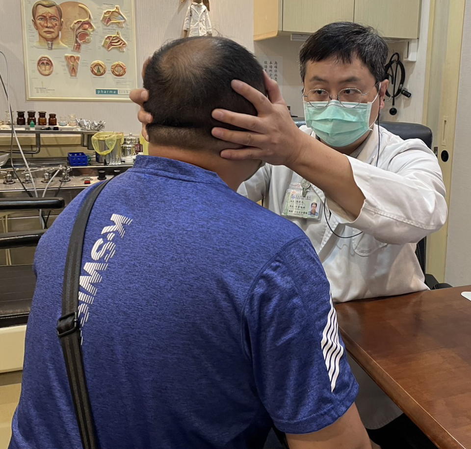 醫師陳建志為長新冠頭痛患者做診療。（醫師陳建志提供）