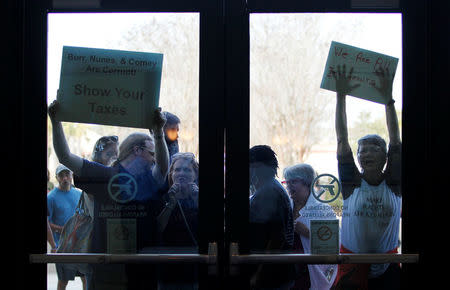 People who could not get into the event because of space limits, hold signs for their cause outside a town hall meeting for constituents hosted by U.S. Senator Tim Scott (R-SC) in North Charleston, South Carolina, U.S. February 25, 2017. REUTERS/Randall Hill