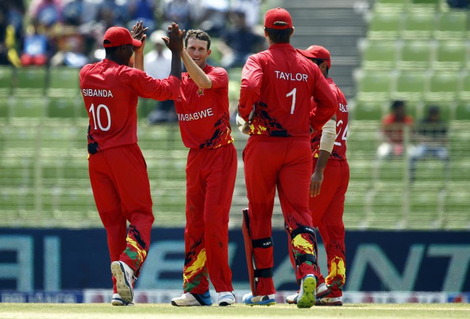 Zimbabwe's Sean Williams, second left, celebrates with his teammates the dismissal of United Arab Emirates' captain Khurram Khan during their ICC Twenty20 Cricket World Cup match in Sylhet, Bangladesh, Friday, March 21, 2014. (AP Photo/A.M. Ahad)