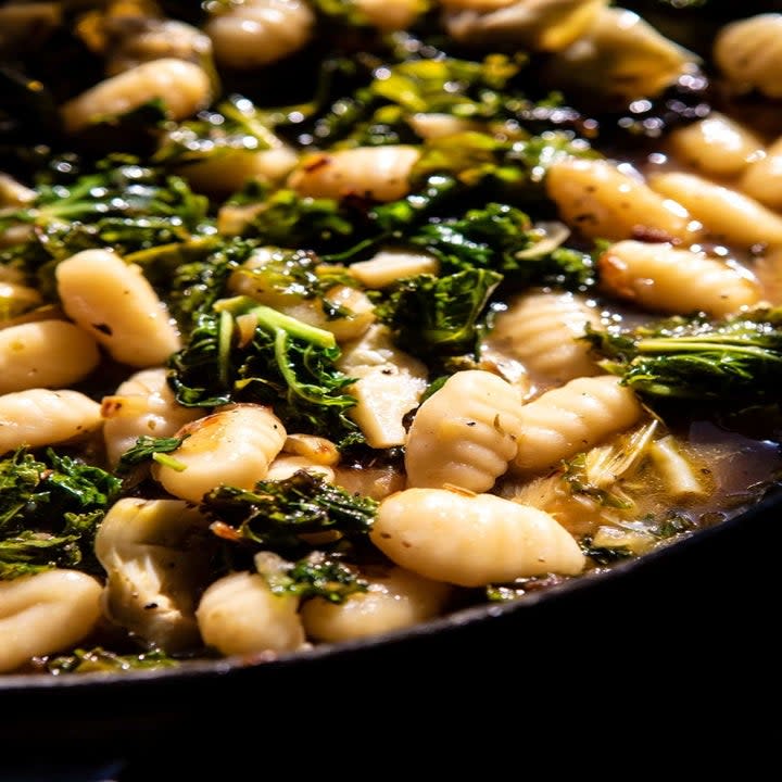Gnocchi and spinach in a skillet.