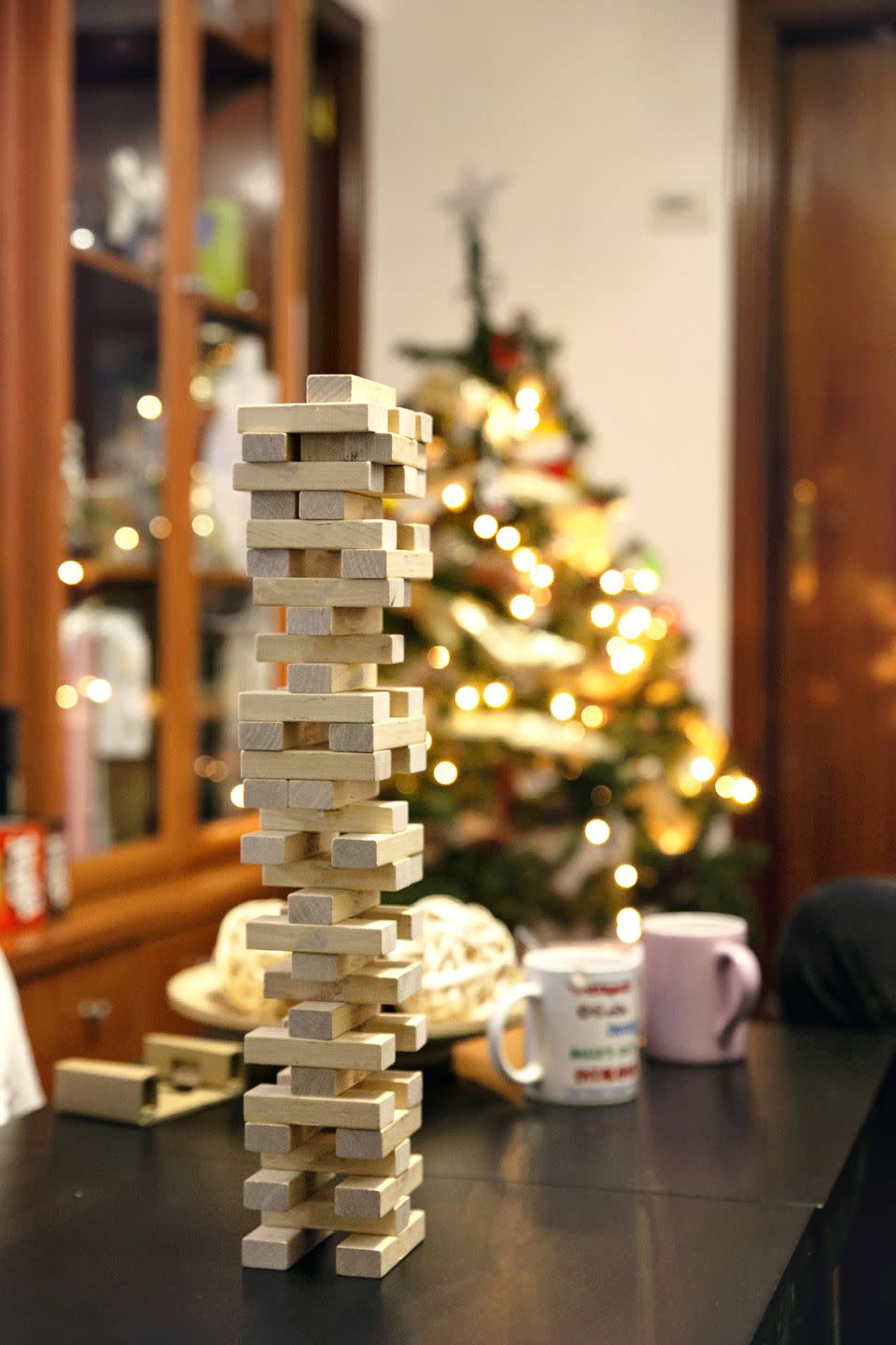 closeup of a set of stacked wooden blocks on the dining table next to the christmas tree