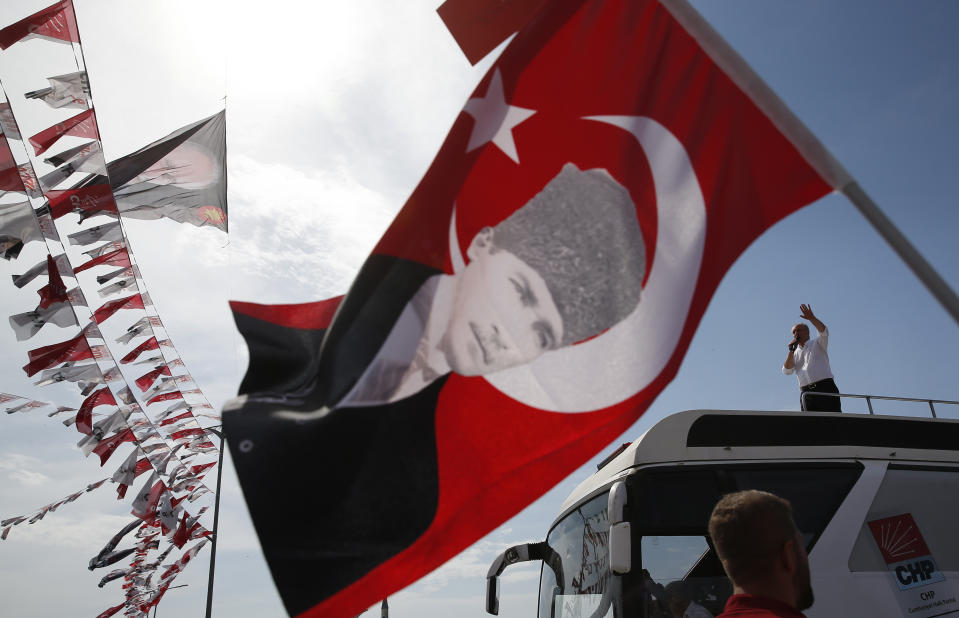FILE - Muharrem Ince delivers a speech at a rally in Istanbul as a supporter waves a Turkish flag decorated with a picture of Turkish Republic founder Mustafa Kemal Ataturk in Istanbul, Turkey, Saturday, June 16, 2018. Muharrem Ince, the leader of the center-left Homeland Party, a candidate in Sunday's elections announced Thursday, May 11, 2023 that he is withdrawing from the presidential race, in a move that is likely to bolster President Recep Tayyip Erdogan's main challenger. (AP Photo/Lefteris Pitarakis, File)
