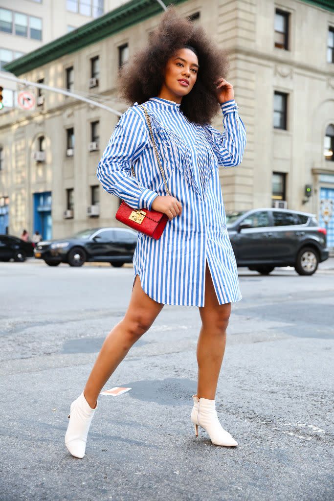 a woman wears a shirt dress with boots in a roundup of the best summer work outfits