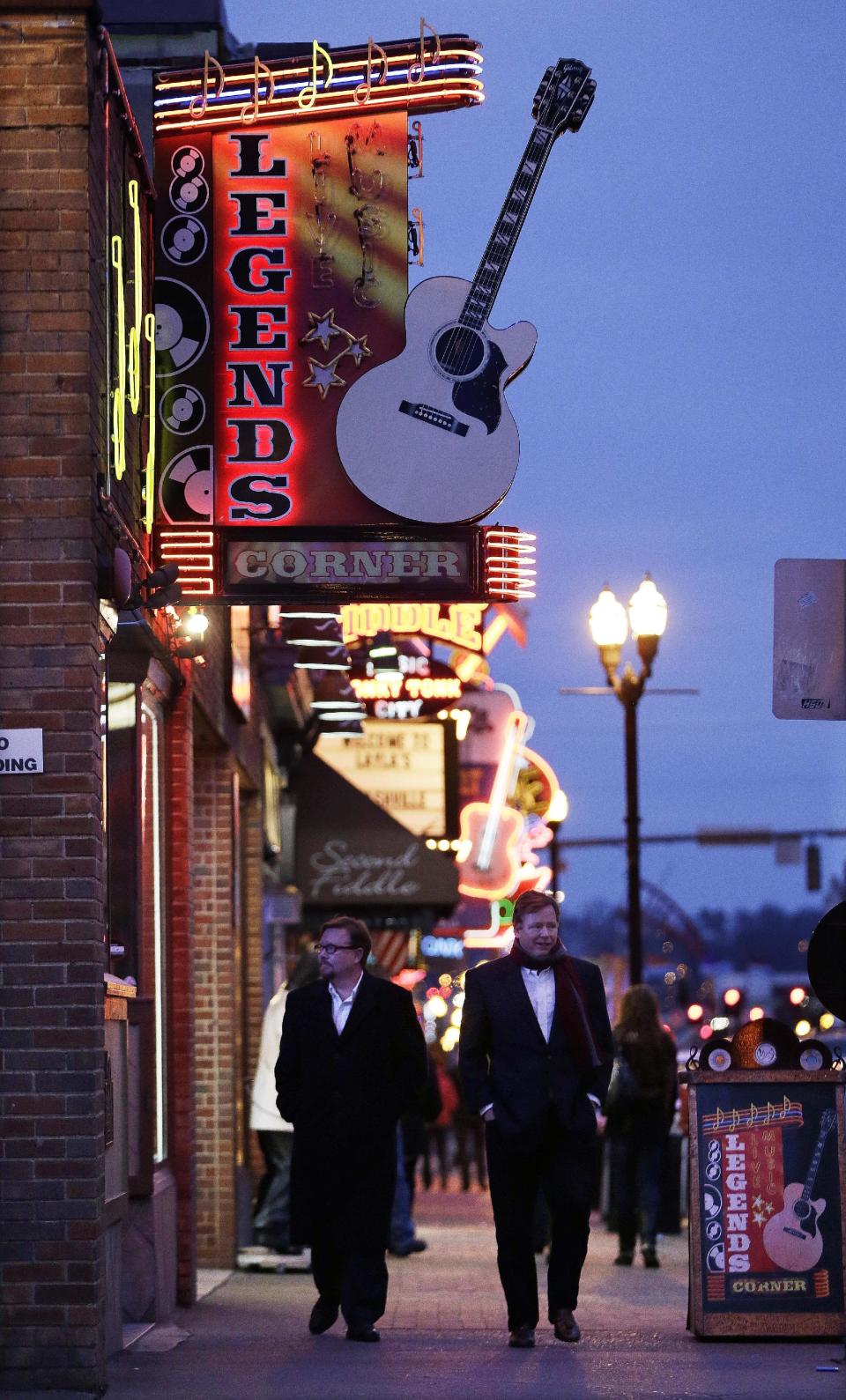 This Jan. 15, 2014 photo shows people walking past a row of bars on lower Broadway in Nashville, Tenn. Live music can be heard every night of the week in the street's honky-tonks and bars. (AP Photo/Mark Humphrey)